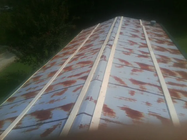 Rusted metal roof panels with new wood purlins before replacement — Storm Damage Roof Repair in Centreville by Roofing Brothers